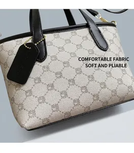 Détail du sac seau rétro à monogramme avec étiquette en cuir noir et dorures chic