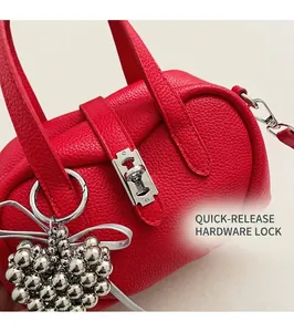 Détail du sac bowling rouge en cuir grainé avec breloque cœur et fermoir tournant