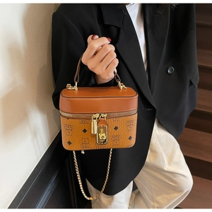 Detail of a brown leather crossbody bucket bag with bear print and golden chain strap