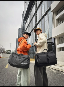 Vue détaillée de grands sacs de voyage noirs et à carreaux pour sport et fitness