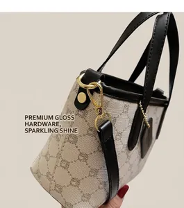 Détails de la boucle dorée brillante et des finitions sur le sac seau beige à motif