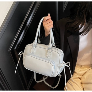 Detail of light blue lychee pattern leather bag with side drawstring bow and front zipper