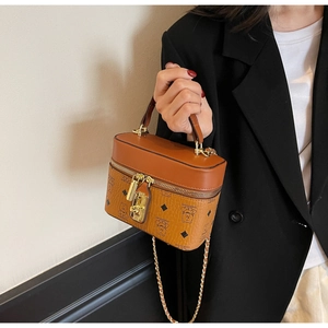 Detail of vintage brown bucket bag showing cartoon bear pattern and gold metal hardware