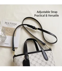 Détail du sac à main blanc à motif floral avec garniture en cuir noir et boucles dorées