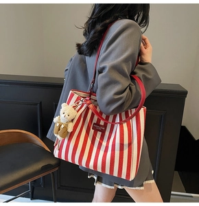 Détail du sac cabas en toile rayé rouge avec un charmant ours en peluche sur la bandoulière