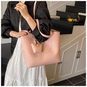 Detailed texture of dusty pink lychee leather tote bag with matching hanging charm