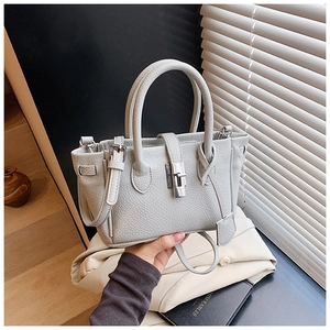 Detailed close-up of light grey litchi grain leather texture and silver rotating lock