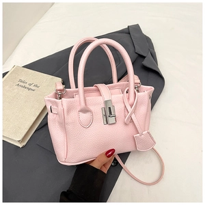 Close-up of pink litchi grain leather texture with silver metal twist lock on bucket bag
