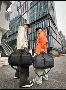 Gros plan de sacs de voyage imperméables noir et à carreaux avec deux poches zippées avant