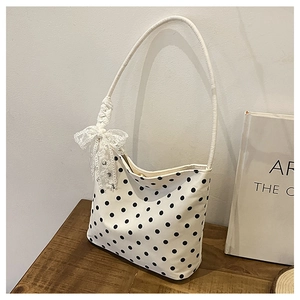 Dettaglio borsa a spalla a pois bianchi con fiocco in pizzo e decorazioni di perline
