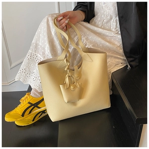Detailed shot of ginger yellow large capacity tote bag and matching mini pouch