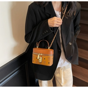 Brown box-shaped crossbody bag with bear pattern and gold chain strap on model