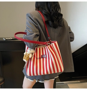 Sac cabas à rayures rouges et blanches avec lanières en cuir porté par un mannequin