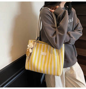 Détails du sac fourre-tout en toile à rayures jaunes et blanches avec breloque ours