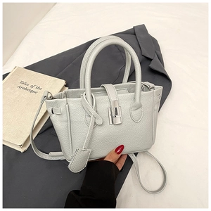 Close-up of pebble leather texture and silver swivel lock on a grey bucket bag