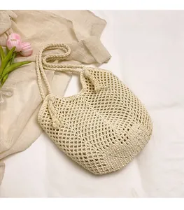 Detailed macro view of the hand-woven knit tote bag featuring a decorative fringe tassel