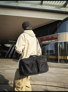 Détail du grand sac cabas noir utilitaire avec poches sur fond urbain moderne