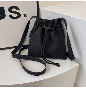 Détail du sac seau noir en nylon avec cordon de serrage et boucle argentée