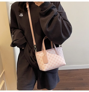 Détail d'un sac seau rose à monogramme avec bandoulière réglable sur mannequin