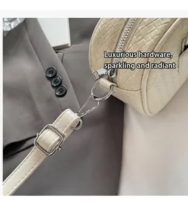 Dettaglio macro della cerniera argentata e dei ganci su una borsa beige intrecciata
