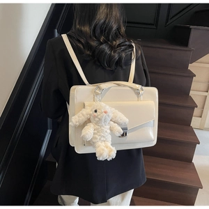 Détail du sac à dos blanc cassé en similicuir avec lapin peluche et poche à rabat