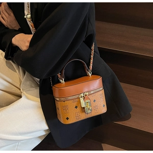 Detail of a brown monogram vanity case bag with metal lock and chain strap