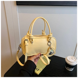 Détail du sac bandoulière jaune clair avec breloque cœur et lettrage doré Fashion & Bags