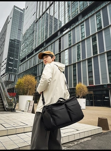 Détail du sac de voyage en nylon noir avec poches zippées et bandoulière réglable amovible