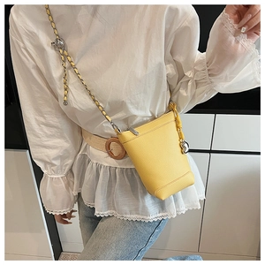 Détail du petit sac à téléphone jaune en cuir grainé avec bandoulière et pompon