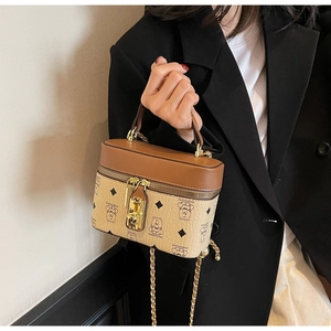 Detail of vintage bucket bag with bear print and golden lock held by a model