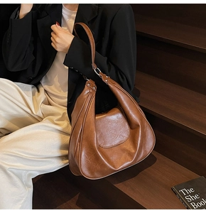 Detail showing vintage brown PU leather texture and contrast stitching on the tote bag