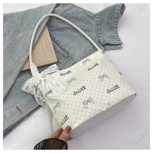 Dettaglio borsa a secchiello bianca a pois con scritta sweet e fiocco in pizzo