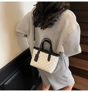 Vue détaillée d'un petit sac cabas à motifs géométriques gris porté par un mannequin