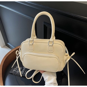 Detail of cream white leather boston bag with lychee texture and front zipper pocket
