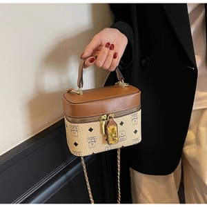 Close-up of a vintage box-style bucket bag with brown leather trim and bear pattern detail