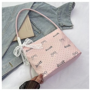 Dettaglio della borsa rosa a pois con fiocco in pizzo bianco e stampa con scritte