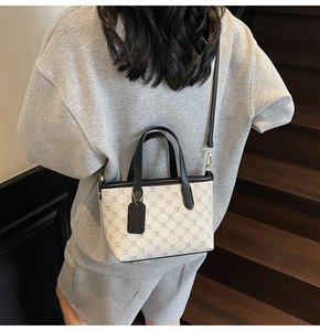 Vue détaillée du sac seau monogramme avec lanières en cuir noir et accessoire pendentif