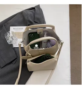 Detail view of cream bucket bag with inner pouch showing spacious interior and daily essentials
