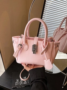 Pink lychee textured bucket bag with silver rotating lock and adjustable shoulder strap