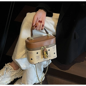 Detail of box-shaped handbag featuring bear prints and elegant gold chain strap