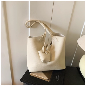 Close-up of cream lychee texture leather tote bag with matching mini charm pouch