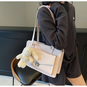 Détail du sac rose avec fermoir rotatif et breloque lapin en peluche blanche
