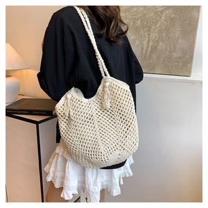 Detailed back view of a beige hollow crochet tote bag with elegant tassel handle details
