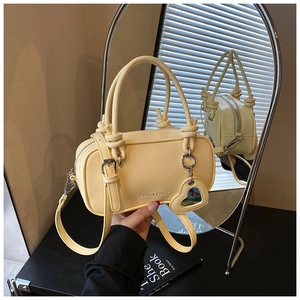 Détail d'un mini sac jaune crème avec breloque cœur et logo texte Fashion & Bags