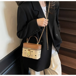 Detailed view of mini bucket bag featuring bear monogram pattern and gold metal clasp lock