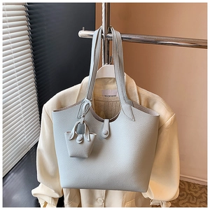 Detail of grey-blue large tote bag with lychee texture and matching mini pouch accessory