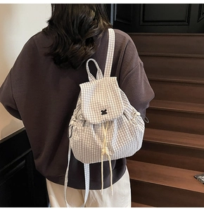 Dettaglio dello zaino leggero da donna con trama a quadri e coulisse decorativa