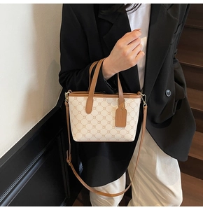 Détail du sac cabas monogramme élégant en toile ivoire avec des lanières en cuir marron