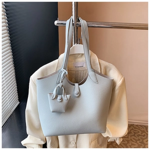 Detail of light blue lychee pattern leather tote bag with matching mini coin purse hanging