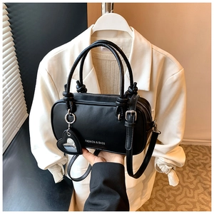 Détail du sac à main noir en cuir avec breloque cœur et inscription Fashion & Bags
